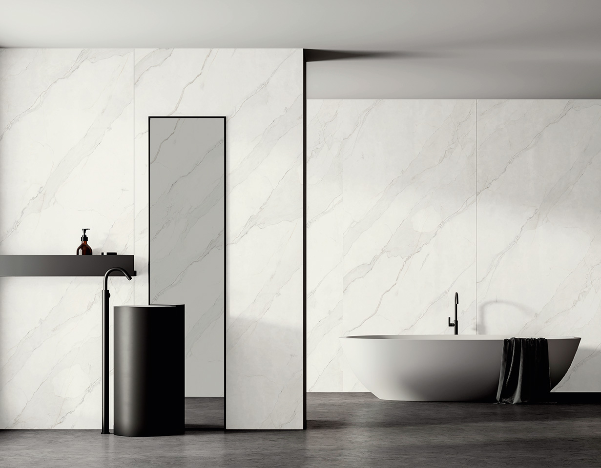 Moderne Raumgestaltung mit großformatigen Wandfliesen in Marmoroptik und passendem Bodenbelag, Waschbecken und freistehender Badewanne.